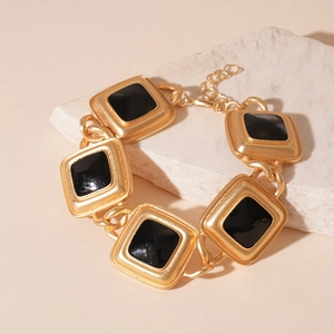 Detail of vintage gold metal chain with black square enamel links and adjustable clasp
