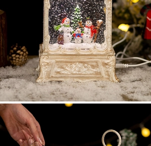 Close-up of retro ivory Christmas snow globe lantern with snowman family figurines