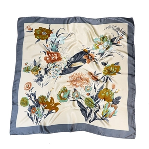 Detail of elegant floral print silk scarf with satin texture and contrast border