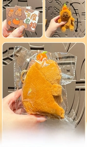 Detail view of plush Capybara keychain with orange head decor and metal clasp