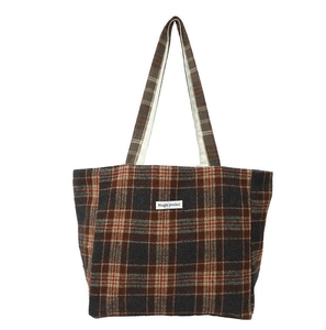 Detail of vintage plaid tote bag featuring red and grey checkered wool texture and straps