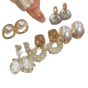 Elegant pearl and rhinestone earring set featuring floral designs and golden metal finish