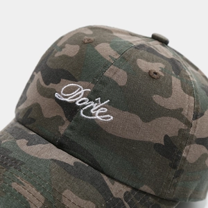 Gros plan sur la broderie blanche Dark et la texture camouflage de la casquette baseball