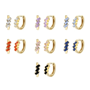 Close-up of gold huggie earrings with baguette-cut gemstones in various colors