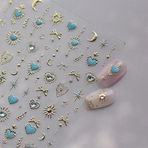 Detailed view of gold and blue nail stickers featuring heart, star, and butterfly patterns