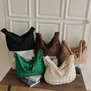 Quilted puffer tote bags in five colors on a wooden table with minimalist decor