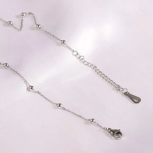 Detailed macro view of silver stainless steel satellite chain with lobster clasp and extension