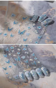 Detailed 5D embossed nail stickers featuring blue butterflies and floral pearl accents