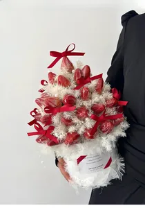 Detail view of a DIY strawberry bouquet with red silk bows and white feathers