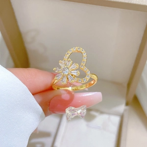 Macro detail of gold rotating flower ring with sparkling zircon heart-shaped cutouts
