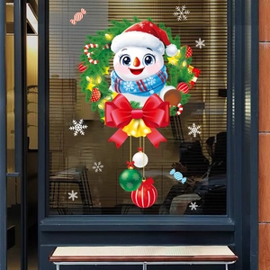 Detail of Christmas snowman window stickers with wreaths and bows on shop glass