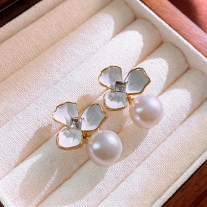 Orecchini a fiore con cristallo quadrato e perle bianche in un portagioie color crema
