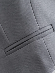 Macro de la texture du tissu en sergé gris et des coutures sur la poche du gilet
