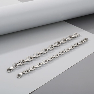 Detail of two silver titanium steel square link chains with lobster clasps on background