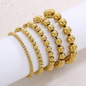Five-piece set of gold beaded elastic bracelets with polished metallic mirror finish