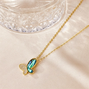 Elegant gold butterfly necklace with colorful shell and zircon on champagne silk fabric