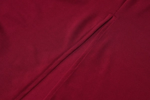 Detailed view of the red knitted fabric and precise seam stitching of the slim midi dress