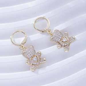 Detail of gold bear earrings featuring white zircon pavé and heart-shaped center stone