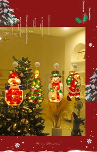 Detail of Christmas LED suction cup lights featuring Santa and snowman on window glass