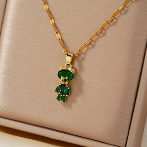 Elegant gold necklace featuring a sparkling green crystal bear pendant in jewelry box