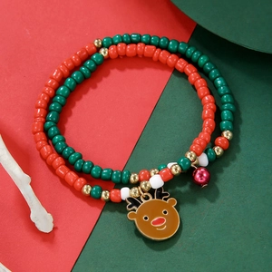 Detailed view of Christmas beaded bracelet with reindeer charm and bells on festive background