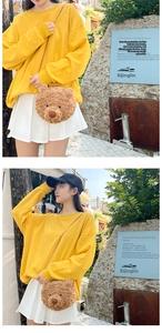 Cute brown plush bear head crossbody bag worn with yellow sweatshirt and white pleated skirt