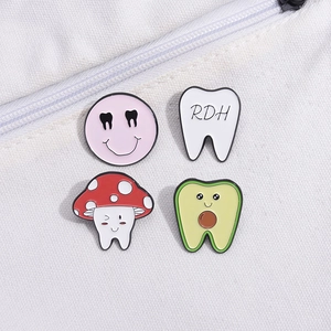 Cartoon dental enamel pin set featuring RDH mushroom and avocado teeth designs on canvas