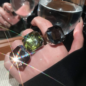 Macro shot of square-cut crystals on adjustable rings with shimmering light effects