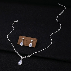 Close-up of silver bridal jewelry set with sparkling zircon waterdrop tassels and necklace
