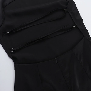 Detail of backless dress showing criss-cross straps and hidden zipper on black fabric
