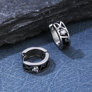 Macro detail of silver steel hoop earrings with black enamel pattern and clear zircon