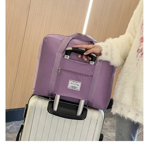 Detail of purple nylon travel bag sleeve sliding over a luggage trolley handle
