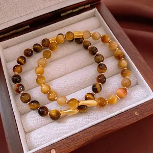 Bracelet en pierres d'oeil de tigre avec pendentif poisson doré dans un coffret en bois chic