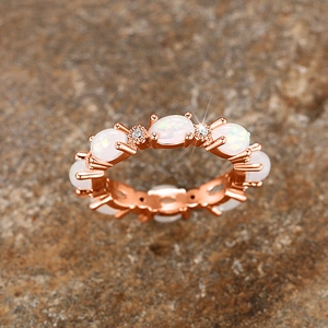Détail de la bague éternité en or rose avec opales blanches ovales et zircons