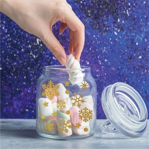 Close-up of golden glitter snowflake stickers on a glass jar for festive winter decor