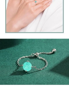 Detail of adjustable silver chain ring featuring a round cyan gemstone and slider clasp