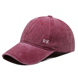 Detailed close-up of side white RK letter embroidery on burgundy washed cotton baseball cap