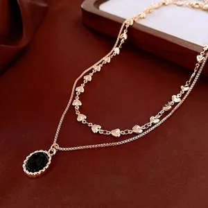 Vintage gold layered necklace featuring a black oval gemstone and heart link chain