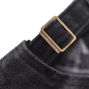 Detail of adjustable vintage bronze metal buckle on classic washed black denim baseball cap