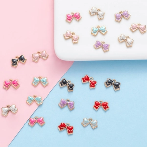 Colorful alloy bowknot pendants for DIY jewelry making displayed on a two-tone background