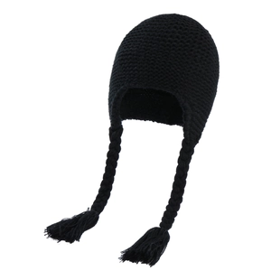 Detail of black cable knit baby hat with earflaps and braided tassel accents