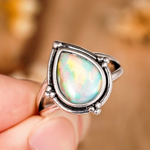 Détail macro d'une bague opale vintage en forme de goutte et argent antique