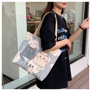 Detailed view of the large capacity canvas tote bag with cute cartoon cat prints