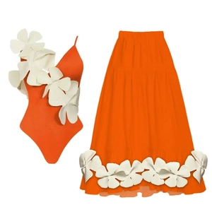 Detail of orange swimsuit and skirt set featuring oversized white 3D floral appliques
