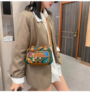 Detail of color-block crossbody bag with colorful rivets and metal rings on khaki suit