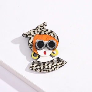 Artistic acrylic girl brooch with sunglasses and yellow earrings on white pedestal