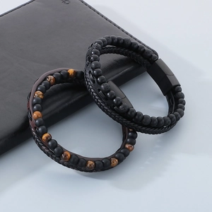 Close-up of mens multi-layer tiger eye stone beads and woven leather bracelet with magnetic clasp