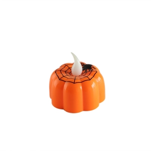 Halloween pumpkin LED candle with spider web pattern on a plain white background