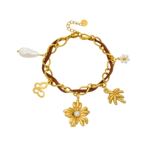 Bracciale a catena dorata con ciondoli a farfalla, fiori di perla e palma su sfondo bianco