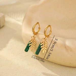 Golden leaf earrings with green marble stones and size dimensions on ceramic tray